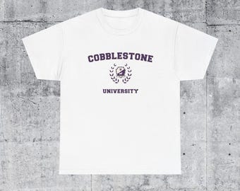 May include: White t-shirt with a purple print that says "Cobblestone University" with a crest and laurel wreath.