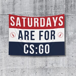 May include: A rectangular banner with the text "SATURDAYS ARE FOR CS:GO" in white letters. The banner has red, white, and blue horizontal stripes, with a star and bottle graphic on each side of the middle stripe.