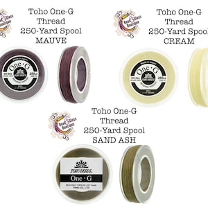 May include: Three spools of Toho One-G Beading Thread, each in a different color: mauve, cream, and sand ash. Each spool contains 250 yards of thread.