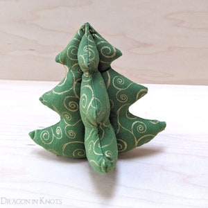 May include: A green fabric Christmas tree with gold swirl patterns. The tree is made of soft material and has a three-dimensional shape. The tree is a festive decoration for the holiday season.