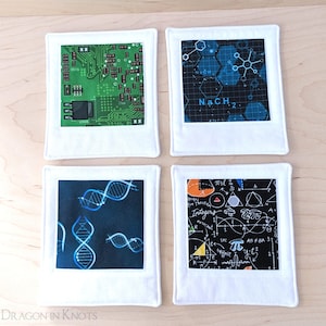 Puede incluir: Juego de cuatro posavasos cuadrados con bordes blancos. Cada posavasos presenta un diseño diferente con temática científica: una placa de circuito verde, estructuras moleculares azules, hebras de ADN y ecuaciones matemáticas. Los posavasos son de tela.