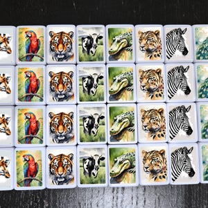 May include: A set of 36 white tiles with colorful animal illustrations. Each tile features a different animal, including a giraffe, a parrot, a tiger, a cow, an alligator, a leopard, a zebra, and a peacock.