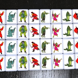 May include: A set of 36 square tiles with colorful illustrations of various Halloween characters. The tiles are white with black borders and feature characters like a vampire, a ghost, a zombie, a witch, a pirate, and a monster.