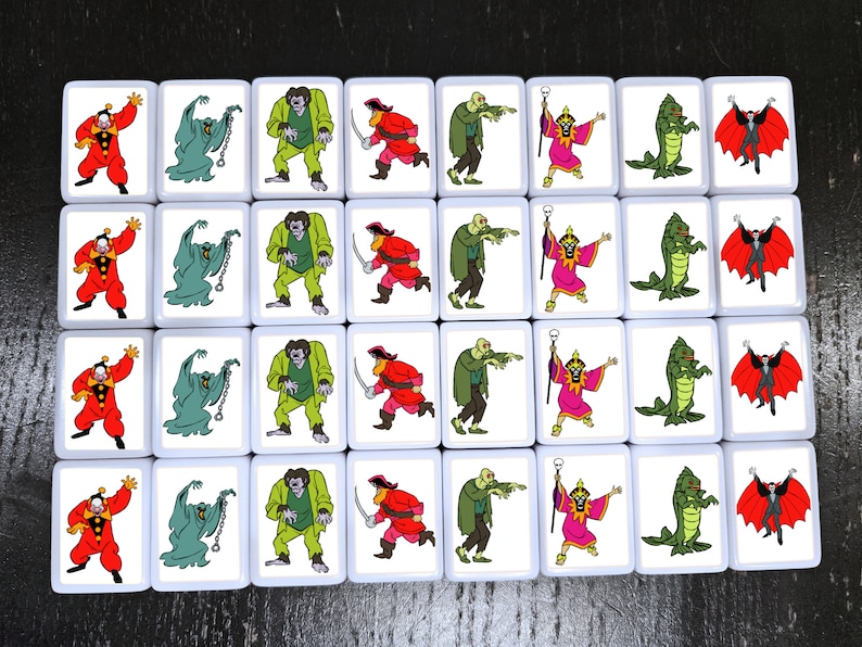 May include: A set of 36 square tiles with colorful illustrations of various Halloween characters. The tiles are white with black borders and feature characters like a vampire, a ghost, a zombie, a witch, a pirate, and a monster.