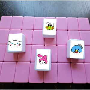 May include: Four white square tiles with cartoon characters on a pink background. The tiles feature a frog, a penguin, a bunny, and a dog.