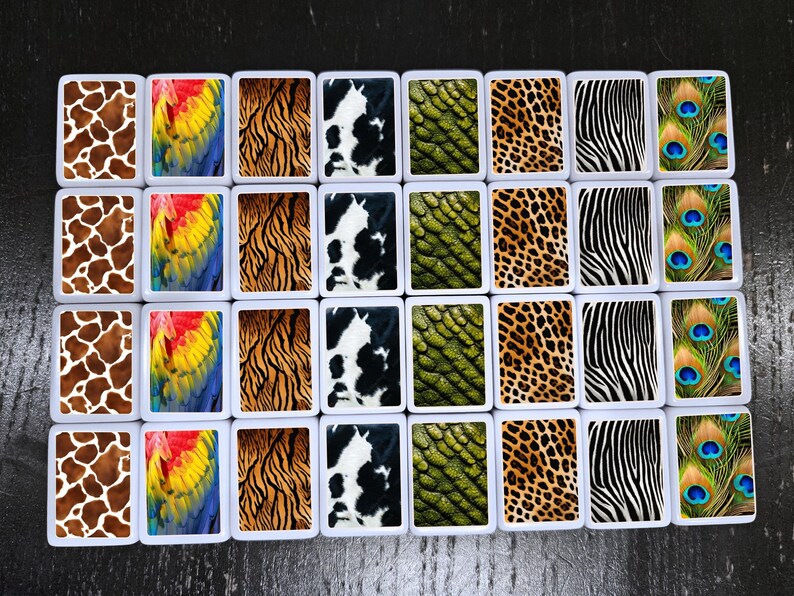 May include: Twenty-four white square tiles with different animal print designs. The designs include giraffe, peacock, zebra, tiger, cow, and snake patterns.
