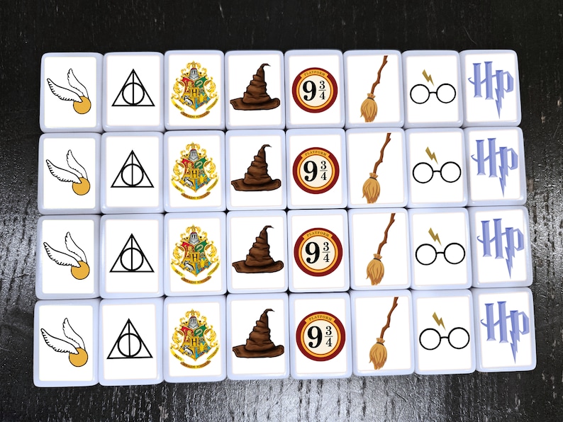 May include: A set of 16 white square tiles with various Harry Potter themed images. The images include the Hogwarts crest, a Sorting Hat, a broomstick, a lightning bolt, a pair of glasses, and the number "9 3/4".