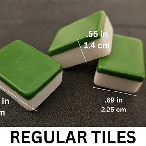 May include: Three green and white mahjong tiles. The tiles are 1.18 inches long and .89 inches wide. The tiles are 3 cm long and 2.25 cm wide.  REGULAR TILES