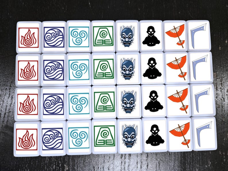 May include: A set of white tiles featuring various symbols and characters from a popular animated series. The tiles display images of fire, water, air, earth, and characters in red, blue, green, and black. The tiles are arranged in rows and columns.