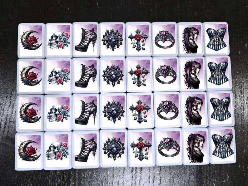 May include: A set of 20 white square tiles with various gothic-themed images. The images include a crescent moon, a skull, a high-heeled shoe, a jeweled cross, a ring, a woman with long dark hair, and a corset.