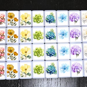 May include: A collection of rectangular tiles, each featuring a watercolor floral design. The designs include roses, poppies, succulents, hydrangeas, and dahlias in various colors like pink, yellow, green, blue, and purple.