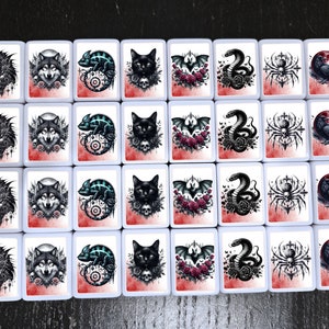 May include: Set of 16 white ceramic tiles with black and white illustrations of animals, insects, and plants. Each tile has a different design, including a wolf, a chameleon, a spider, a bat, a skull, and a rose.