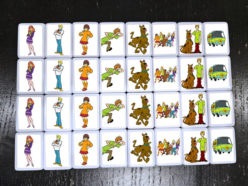 May include: A set of 20 square tiles featuring characters from the Scooby-Doo cartoon. Each tile has a different image, including Scooby-Doo, Shaggy, Velma, Daphne, and Fred. The tiles are white with a black border and are perfect for playing a game or decorating a room.