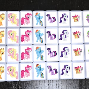 May include: A set of 24 colourful square tiles featuring different My Little Pony characters. Each tile has a white background and a colourful image of a pony or dragon.