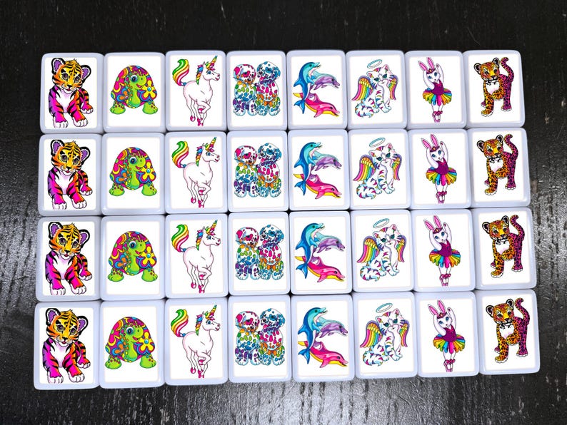 Op de afbeelding: Een set van 20 kleurrijke, vierkante tegels met verschillende afbeeldingen van dieren, waaronder een tijger, een schildpad, een eenhoorn, een paar dolfijnen, een kat met een halo en een konijn in een tutu. De tegels zijn wit met een zwarte omtrek.