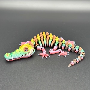 Multi Colored 3D printed crocodile or alligator Skeleton. Fast color changing rainbow for the head with white teeth, and Alternating ribs.