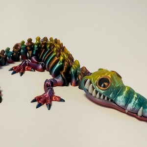 Multi Colored 3D printed crocodile or alligator Skeleton. Fast color changing rainbow for the head with white teeth, and Alternating ribs.