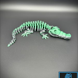 3D printed alligator or crocodile with a a black and green color.