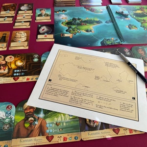 May include: A game board featuring a map of islands, cards with illustrations of people and numbers, and a pen on a white sheet of paper with handwritten notes.