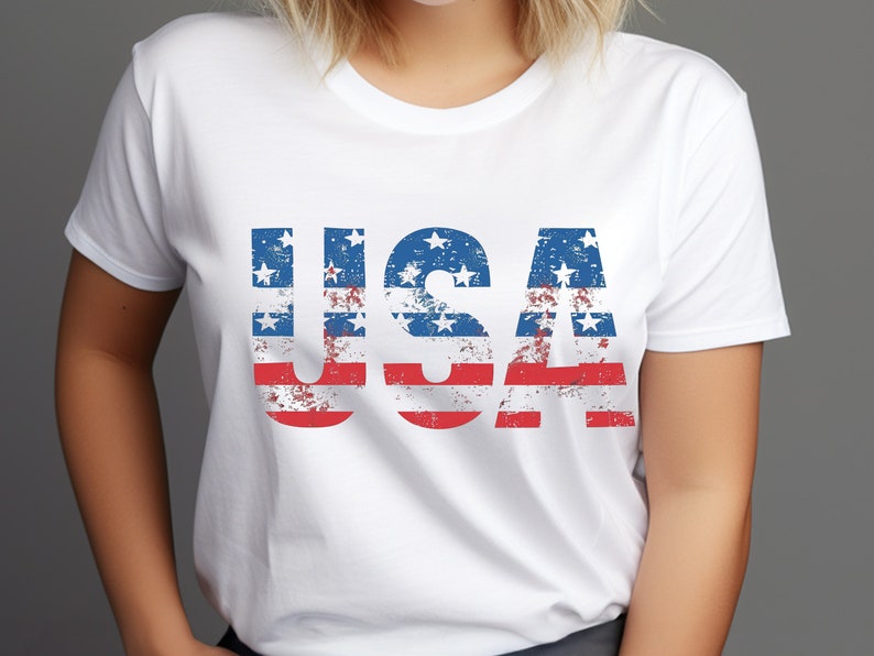 May include: White t-shirt with a distressed American flag design spelling out "USA".