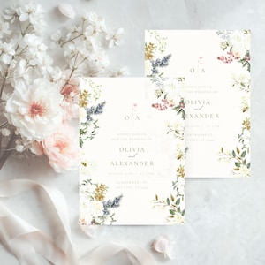 May include: Wedding invitation cards with floral border designs. The cards feature the names "Olivia and Alexander" in elegant script, with the initials "OA" at the top. The design includes white, pink, and blue flowers.