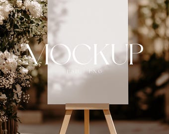 May include: A white sign with the word "MOCKUP" in white text on a wooden easel in front of a floral arrangement.