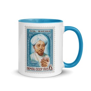 May include: White ceramic mug with a blue rim and handle. The mug features a vintage Soviet postage stamp with a portrait of Al-Farabi, a famous philosopher and polymath, and the text "АЛЬ-ФАРАБИ" (Al-Farabi) and "ПОЧТА СССР 1975 6к" (USSR Post 1975 6 kopecks).