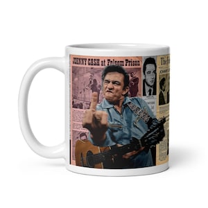 Puede incluir: Taza de cerámica blanca con un diseño que presenta a Johnny Cash. El diseño incluye una foto de Cash haciendo un gesto obsceno, recortes de periódicos y el texto "JOHNNY CASH at Folsom Prison."