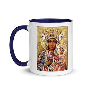 Könnte beinhalten: Weißer Keramikbecher mit marineblauem Griff und Innenraum. Der Becher zeigt eine religiöse Ikone einer Frau und eines Kindes mit Kronen, mit goldenen und juwelenfarbenen Details. Der Hintergrund ist goldfarben.