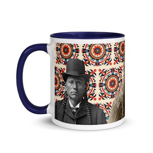 May include: White ceramic mug with a navy blue interior and handle. The mug features a vintage portrait of a man in a bowler hat and braids, set against a cream background with a colorful geometric pattern. A unique and artistic coffee mug.