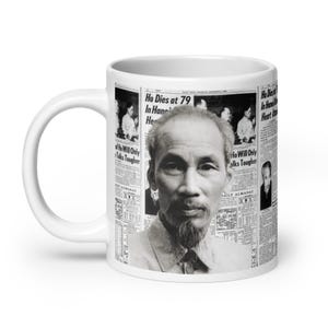May include: White ceramic mug with a black and white image of Ho Chi Minh on a newspaper background. The text on the newspaper reads "Ho Dies at 79 in Hanoi".