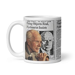 Può includere: Tazza in ceramica bianca con una stampa di giornale d'epoca. Il titolo recita "Flying Objects Real, Psychiatrist Insists". La tazza presenta anche un ritratto di un uomo con gli occhiali. La tazza ha un manico bianco.