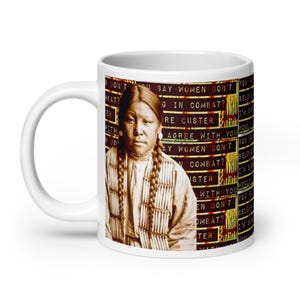 May include: White ceramic mug with a photo of a Native American woman wearing traditional clothing. The mug has text that reads "Don't you say women don't belong in combat?" and "Agree with you? Say women don't belong in combat?"