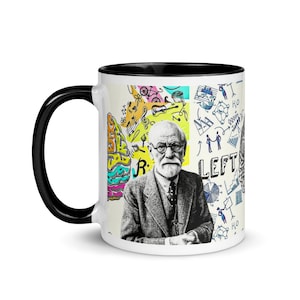 Può includere: Tazza in ceramica bianca con bordo e manico neri. La tazza presenta un'illustrazione colorata di Sigmund Freud, un cervello e la parola "LEFT".