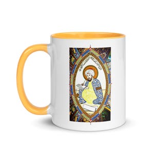May include: White ceramic mug with a yellow rim. The mug features a colorful illustration of a person writing in a book. The illustration is surrounded by a decorative border with Arabic text.