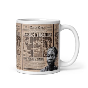 Puede incluir: Taza de cerámica blanca con un diseño de periódico. La taza presenta el titular "LASSIES & LIBATIONS" e imágenes de mujeres. También incluye el texto "NINA 'PEACHES' SIMONE" y es un homenaje al Mes de la Historia de la Mujer.