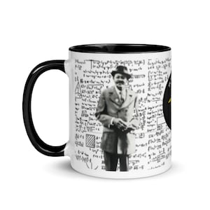 Könnte beinhalten: Eine weiße Keramik-Kaffeetasse mit schwarzem Innenraum und Griff. Die Tasse zeigt ein Schwarz-Weiß-Bild eines Mannes im Anzug, umgeben von mathematischen Gleichungen. Auf der rechten Seite befindet sich ein gelb-schwarzes Emblem.