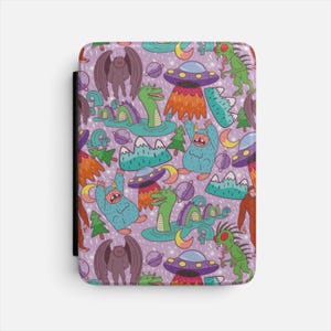Può includere: Una custodia rettangolare per e-reader con un motivo ripetuto su sfondo viola chiaro. Il design include illustrazioni di mostri marini verdi, creature blu pelose, esseri alati marroni, UFO, pianeti, lune crescenti e montagne.