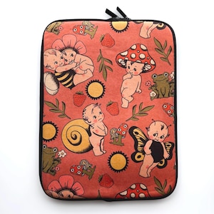 Op de afbeelding: Een roze en rode laptophuls met een grillig ontwerp met baby-kerubijnen, paddenstoelen, slakken en kikkers. De hoes heeft een zwarte rits en zwarte bies.
