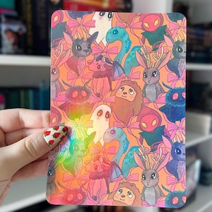 Peut inclure: Une feuille d'autocollants holographiques représentant divers personnages d'animaux mignons avec des nœuds. Les animaux comprennent un lapin, un renard, un chat, un dragon, un fantôme et une mite. La feuille d'autocollants est parfaite pour ajouter une touche de fantaisie à votre agenda, votre ordinateur portable ou votre bouteille d'eau.