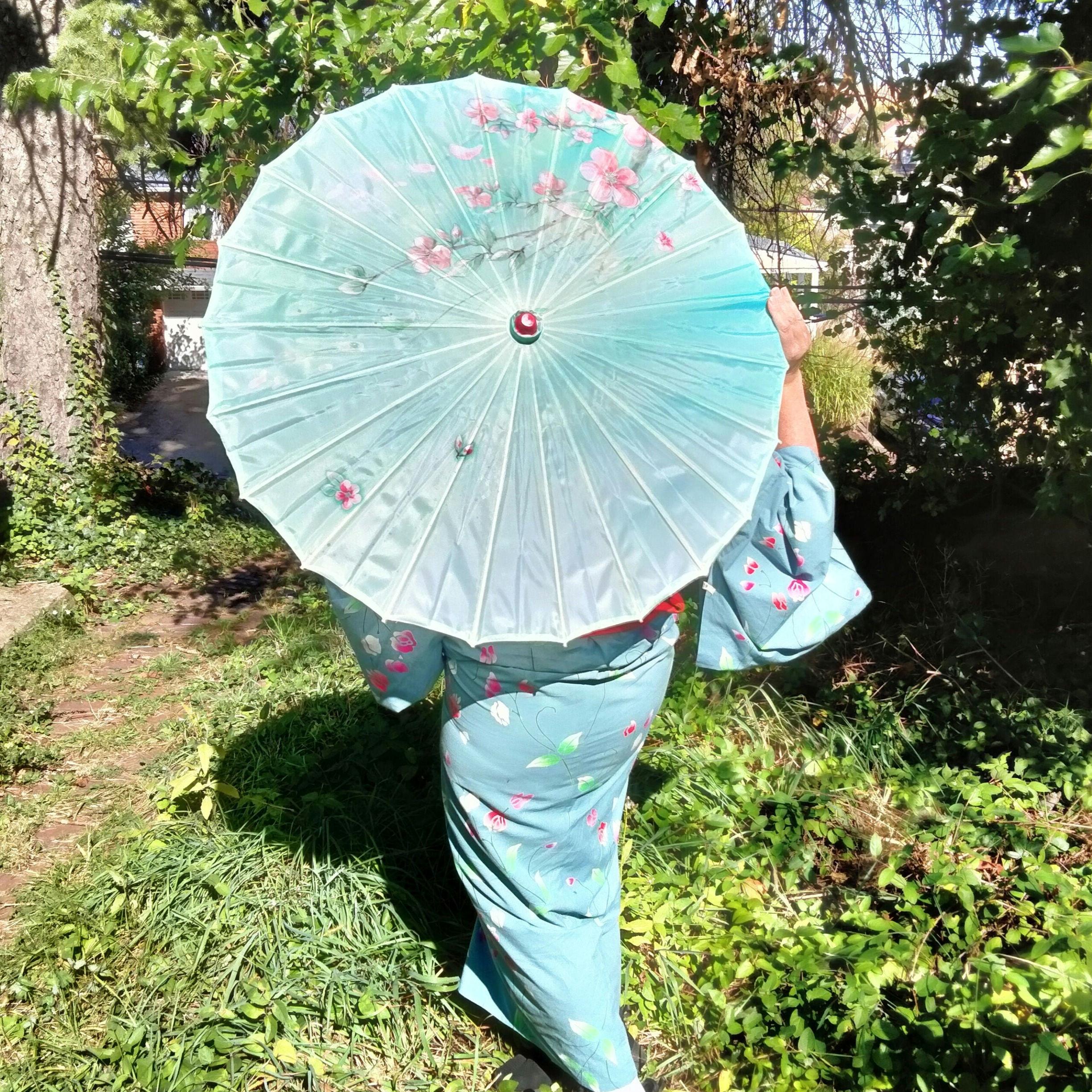 Beautiful floral wagasa umbrella with pink sakura flowers, traditional Japanese parasol perfect for kimono coordination and rainy day styling in Kyoto rental experiences