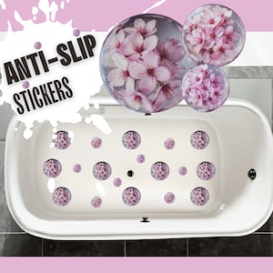 May include: White bathtub with pink floral anti-slip stickers. The stickers are round and have a floral design. The text "ANTI-SLIP STICKERS" is written in white on a black background.