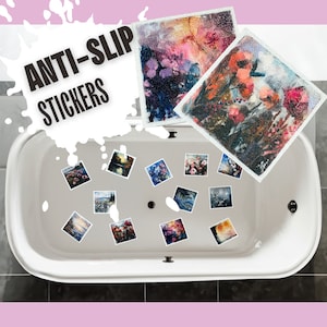 May include: White bathtub with a drain in the center.  The bottom of the tub is covered with colorful anti-slip stickers.  The stickers feature watercolor paintings of flowers and landscapes.  The text "ANTI-SLIP STICKERS" is written in black on a white splatter background.