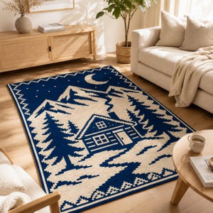 May include: A rectangular area rug featuring a two-tone navy blue and cream pixelated landscape design. The pattern depicts a cabin nestled among pine trees with a mountain range in the background, a crescent moon, and stars in the night sky.