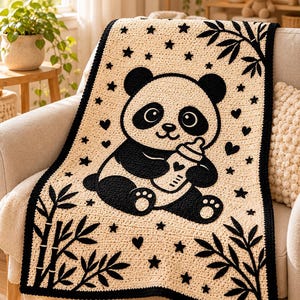 May include: A cream-colored crochet blanket featuring a large black panda bear holding a baby bottle. The design includes black bamboo stalks in the corners, scattered black stars, and small heart shapes across the surface, finished with a black border.