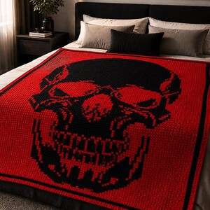 Puede incluir: Una manta roja y negra tejida a ganchillo con un dise&ntilde;o de calavera. La calavera es negra sobre un fondo rojo. La manta es rectangular y parece estar hecha de hilo suave.