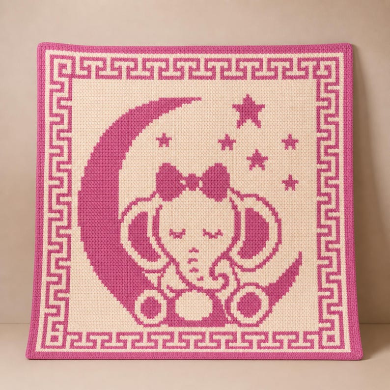 May include: A pink and cream-colored crocheted baby blanket. The blanket features a pink elephant sitting on a crescent moon, surrounded by stars. A pink border with a Greek key design frames the image.