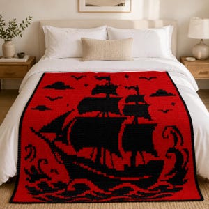 May include: A rectangular throw blanket featuring a bold red background with a large, black, pixelated graphic of a sailing ship on the ocean. The design includes black clouds, birds, and stylized waves, creating a high-contrast nautical pattern.