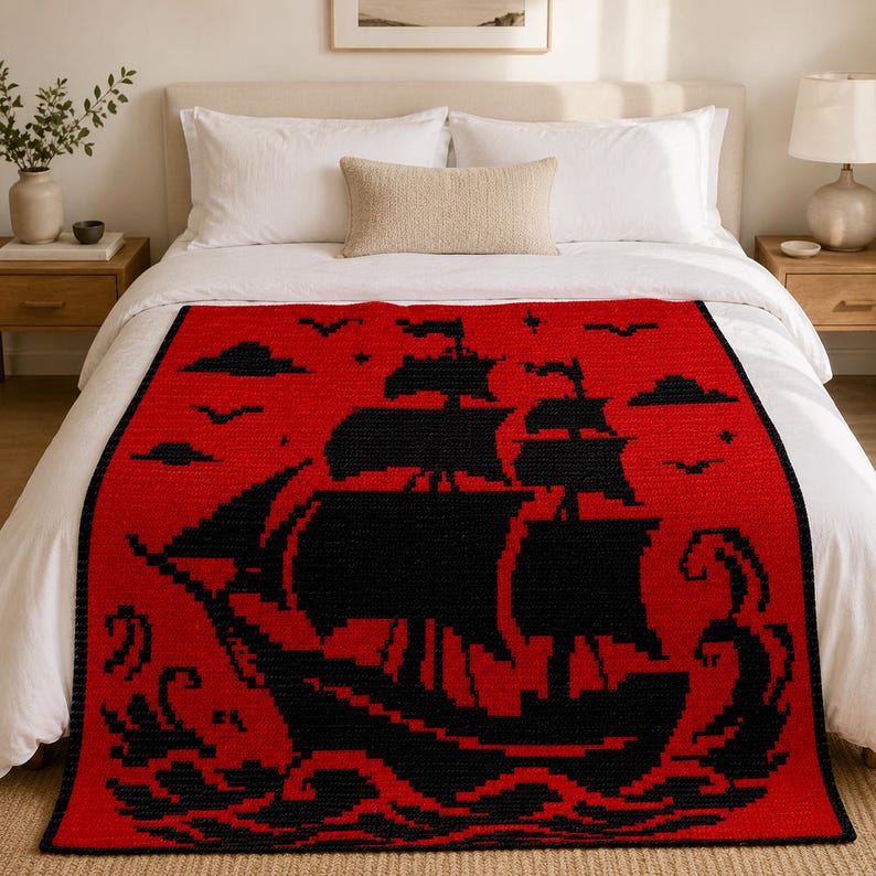 May include: A rectangular throw blanket featuring a bold red background with a large, black, pixelated graphic of a sailing ship on the ocean. The design includes black clouds, birds, and stylized waves, creating a high-contrast nautical pattern.