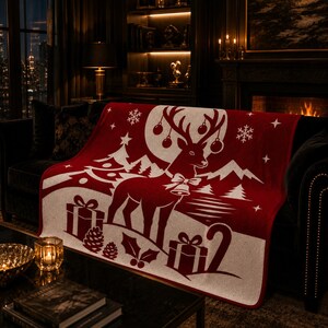 Pode incluir: Uma manta vermelho-escura e branca com uma rena central grande com chifres decorados com enfeites, uma coleira com sino e um fundo de pinheiros, montanhas, flocos de neve, estrelas, caixas de presente, pinhas e folhas de azevinho.